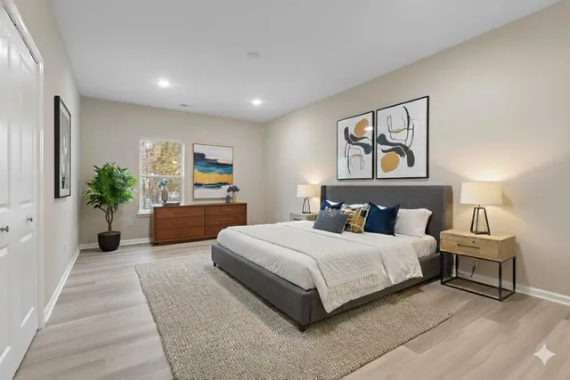 a bedroom with a large bed and a potted plant