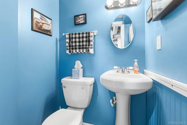 a bathroom with a toilet a sink and a mirror