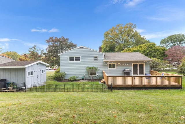 a view of a house with a big yard and large trees