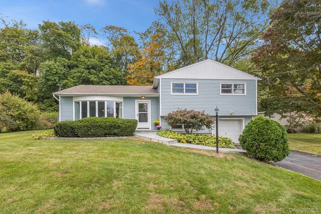 a front view of a house with yard and green space