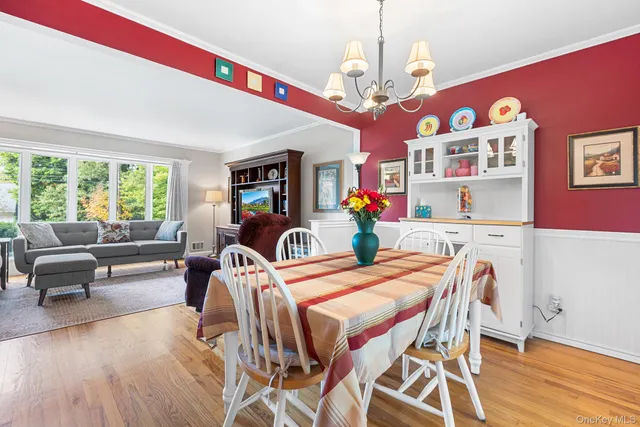 a view of a dining room with furniture a chandelier and wooden floor