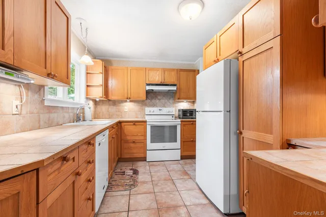 a kitchen with a refrigerator sink and cabinets