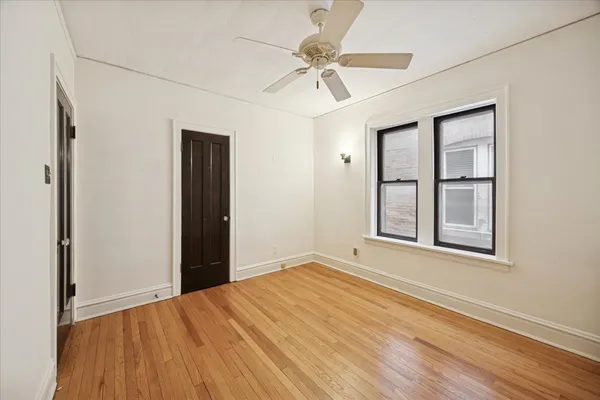 an empty room with windows and fan