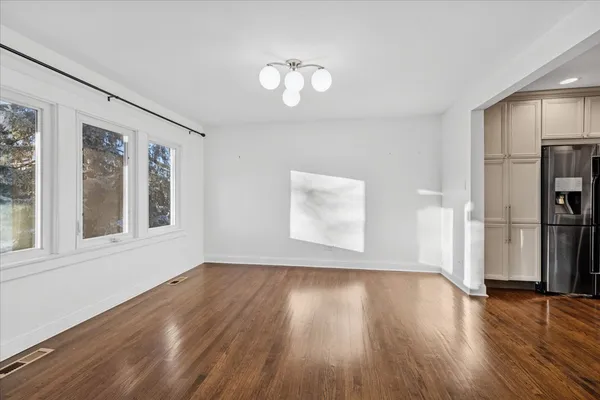 a view of empty room with wooden floor and window