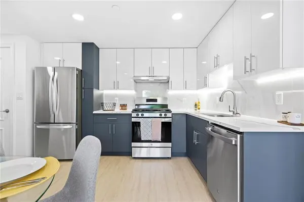 a kitchen with kitchen island a stove a sink and a refrigerator