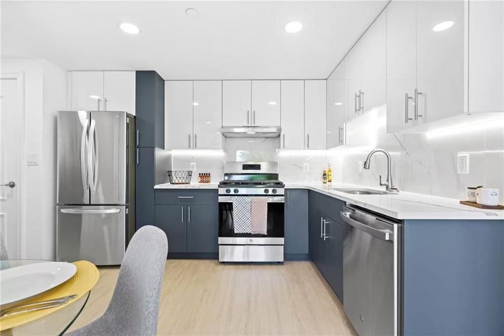42-80 Main Street, Unit 5E Queens, NY 11355 - Photo 2 of 11 a kitchen with kitchen island a stove a sink and a refrigerator