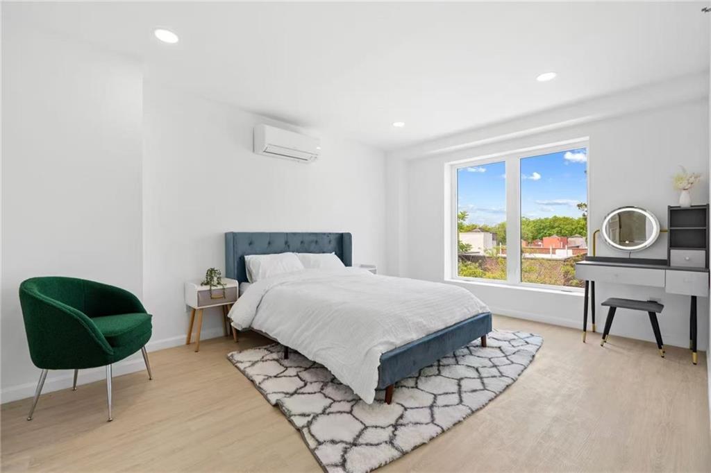 42-80 Main Street, Unit 5E Queens, NY 11355 - Photo 4 of 11 a bedroom with a bed and a lamp next to a window