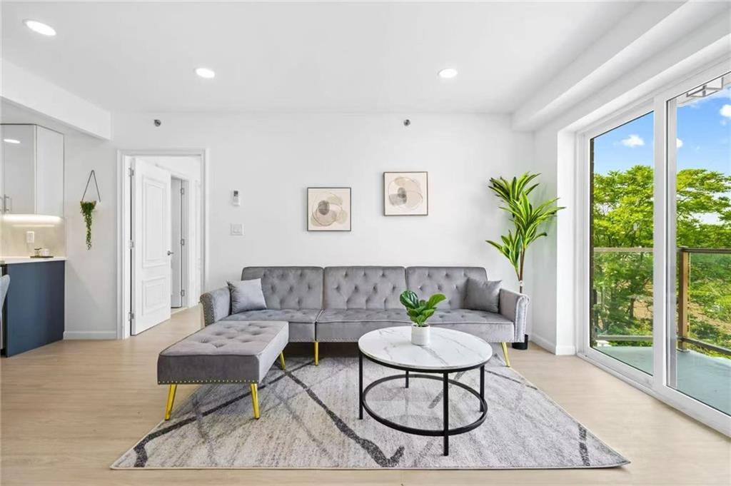 42-80 Main Street, Unit 5E Queens, NY 11355 - Photo 6 of 11 a living room with furniture and a floor to ceiling window