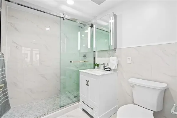 a bathroom with a sink a toilet and shower