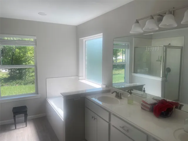 a bathroom with a granite countertop sink a toilet and a window