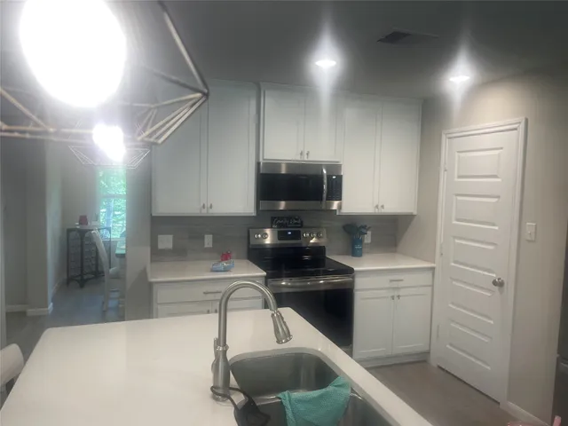 a kitchen with a sink stainless steel appliances and cabinets