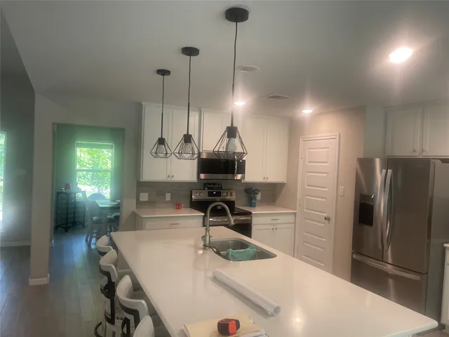 a kitchen with a sink a refrigerator and a stove