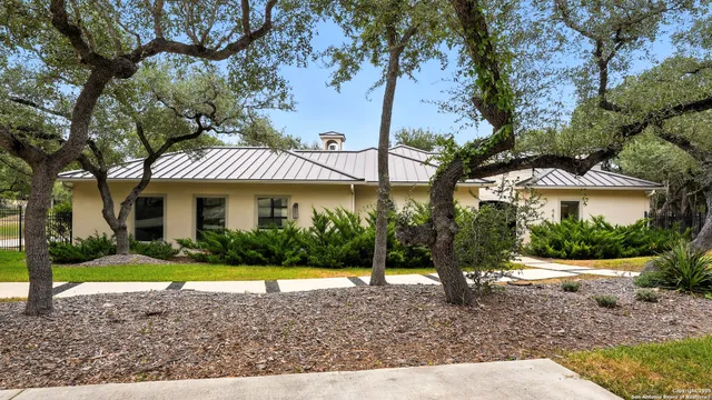a view of a house with a yard and table and chairs under an umbrella