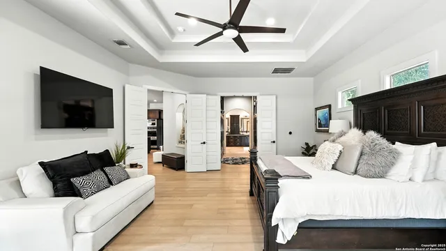 a bedroom with a bed a couch and a flat screen tv