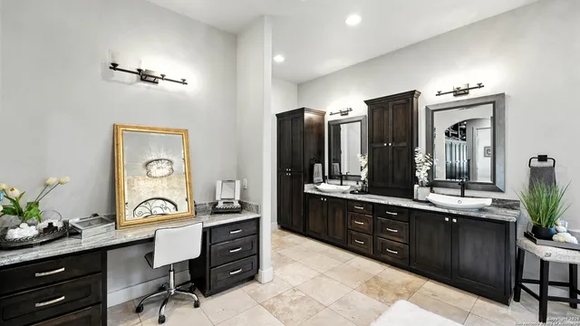 a en suite bathroom with a granite countertop sink and a mirror