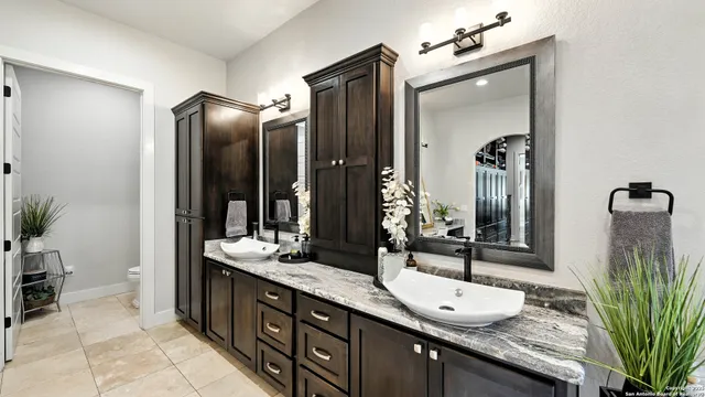 a bathroom with a granite countertop sink and a mirror