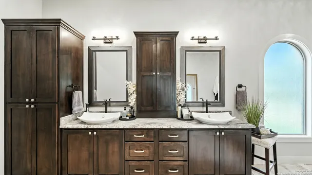 a bathroom with double vanity sinks and a mirror