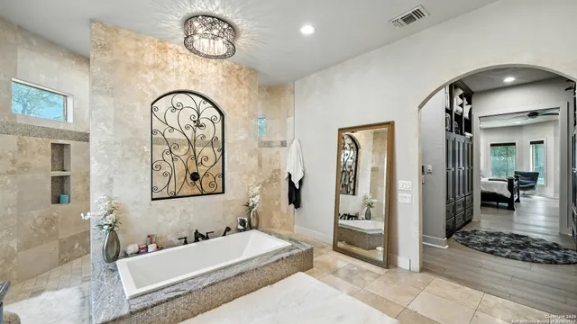 a spacious bathroom with a mirror a bathtub and shower