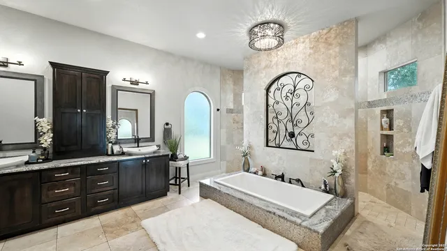 a spacious en suite bathroom with a granite countertop tub and a large mirror