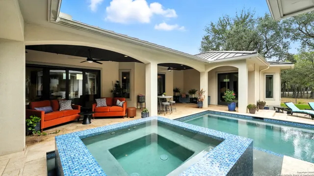 a view of a house with swimming pool and sitting area