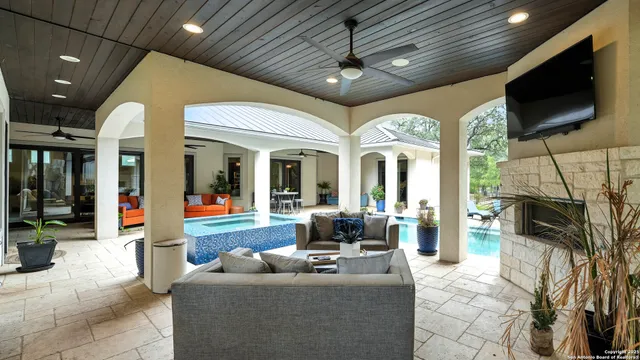 a living room with furniture a flat screen tv and a chandelier
