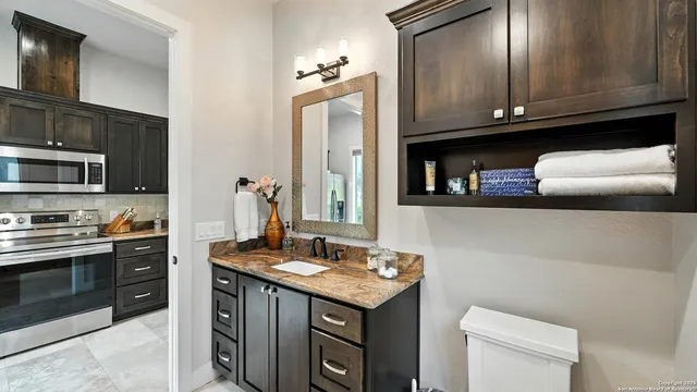 a kitchen with granite countertop a sink cabinets and stainless steel appliances