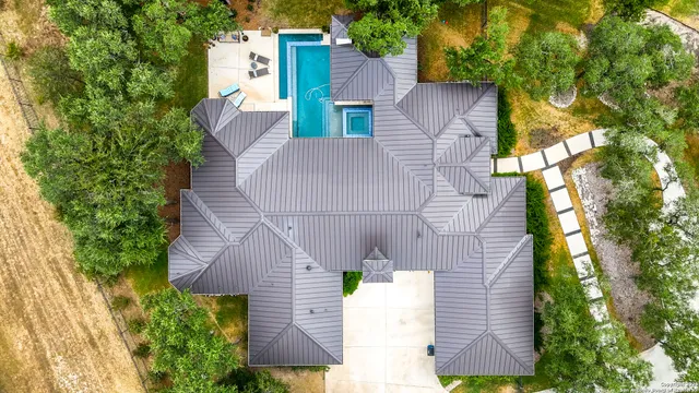 an aerial view of a house with a yard and large trees