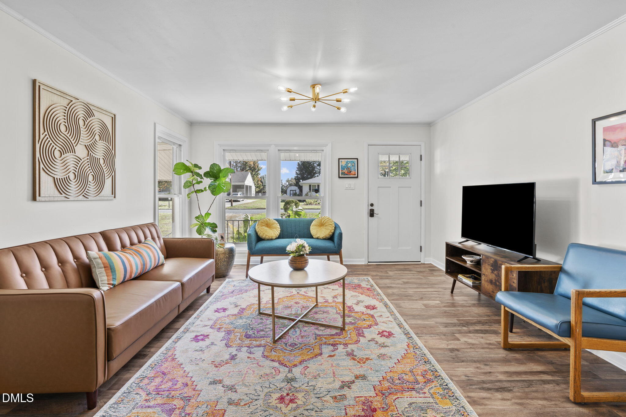 3307 Winston Road Durham, NC 27704 - Photo 9 of 22 a living room with furniture a chandelier and a flat screen tv