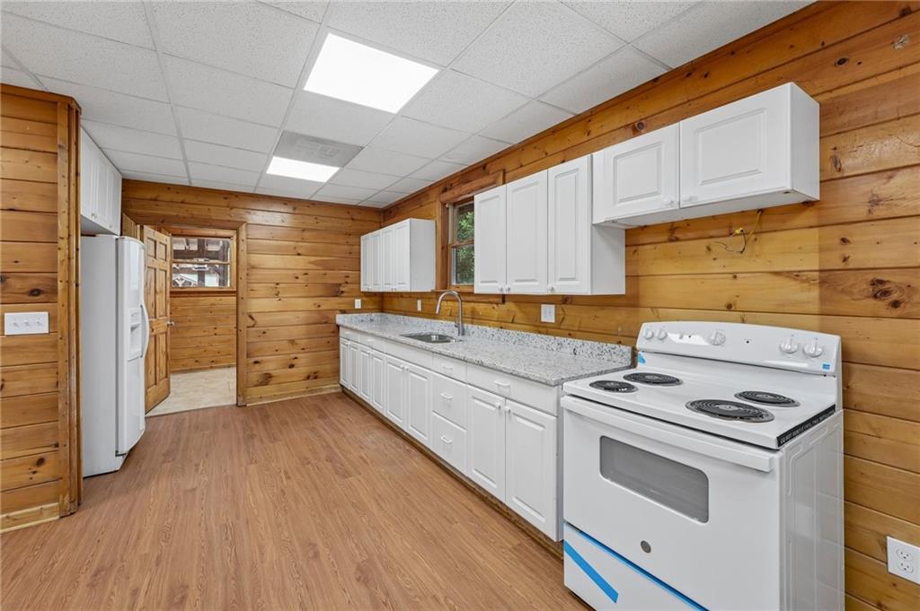 1384 Crystal Lane Northeast Ranger, GA 30734 - Photo 43 of 89 a kitchen with stainless steel appliances a stove a sink and white cabinets with wooden floor