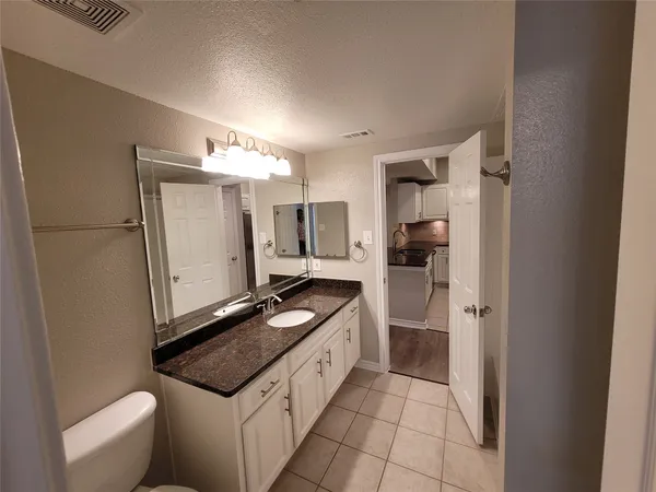 a kitchen with granite countertop a refrigerator and a sink