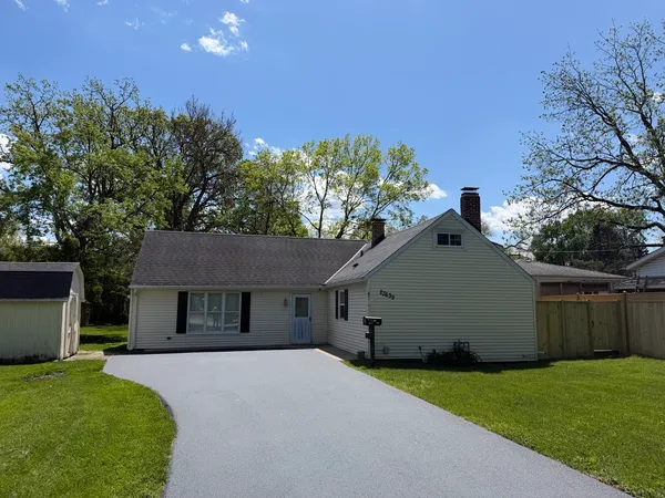 a front view of a house with a garden and yard