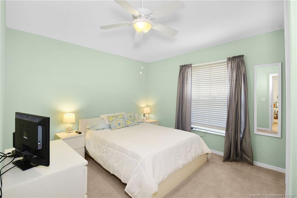 486 Northwest Sunflower Place Stuart, FL 34994 - Photo 20 of 42 a bedroom with a bed and a lamp