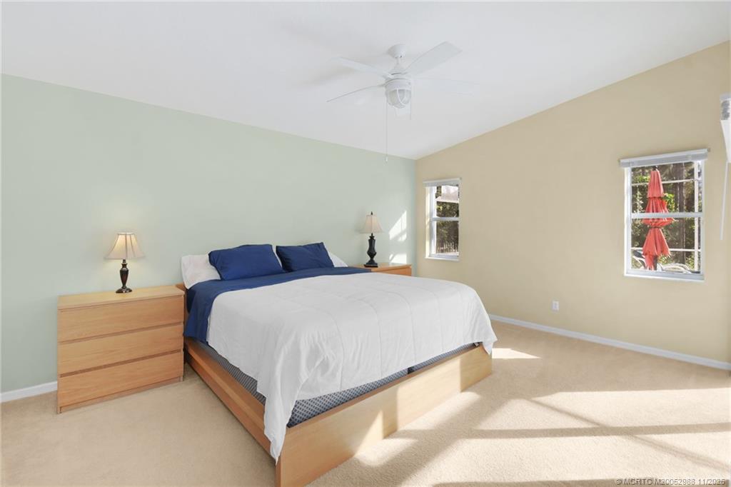 486 Northwest Sunflower Place Stuart, FL 34994 - Photo 25 of 42 a bedroom with a bed and a night stand