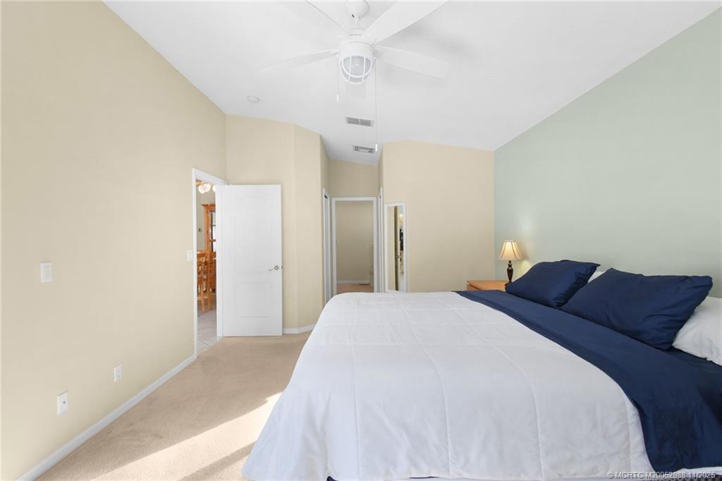 486 Northwest Sunflower Place Stuart, FL 34994 - Photo 27 of 42 a bedroom with a bed and a ceiling fan