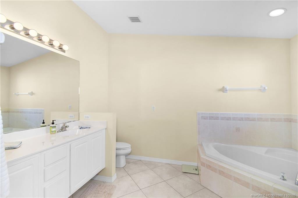 486 Northwest Sunflower Place Stuart, FL 34994 - Photo 28 of 42 a bathroom with a double vanity sink toilet and bathtub