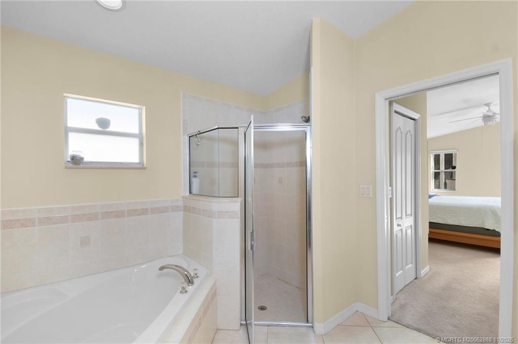 486 Northwest Sunflower Place Stuart, FL 34994 - Photo 29 of 42 a bathroom with a bathtub and a shower