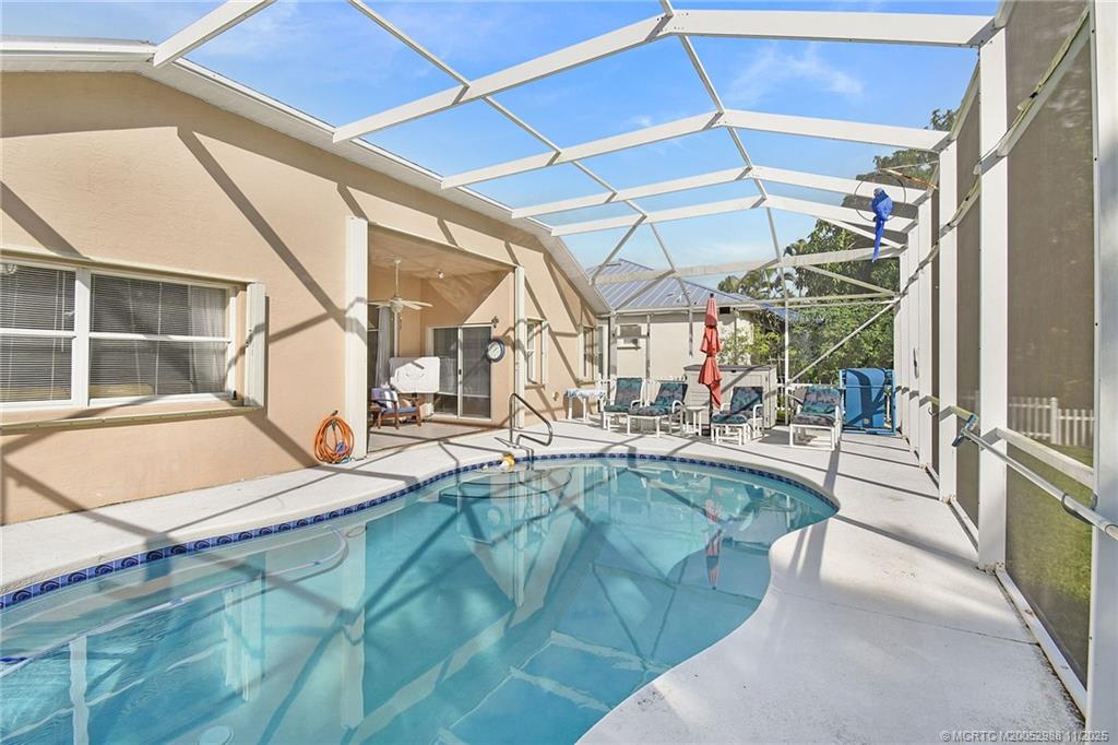 486 Northwest Sunflower Place Stuart, FL 34994 - Photo 35 of 42 a view of a living room with a floor to ceiling window and outdoor kitchen
