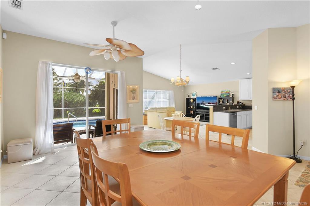 486 Northwest Sunflower Place Stuart, FL 34994 - Photo 9 of 42 a dining room with furniture a chandelier and wooden floor
