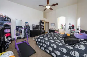 a bed room with a bed a dresser and a chandelier