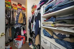 a view of walk in closet with clothes and shoes