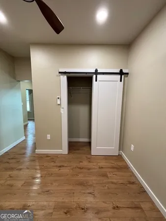 an empty room with wooden floor and closet