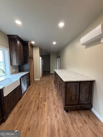 a kitchen with a sink and wooden floor