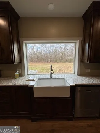 a kitchen with a sink a window and cabinets
