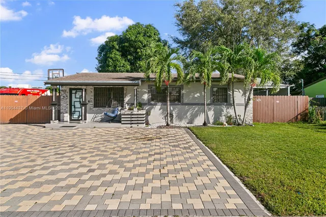 a view of a house with backyard and sitting area