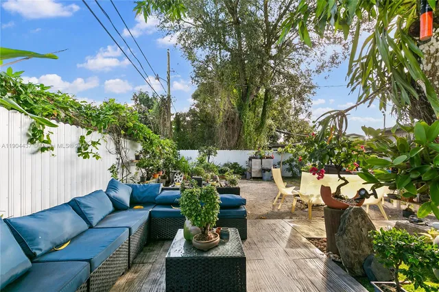 a view of a backyard with couches and potted plants