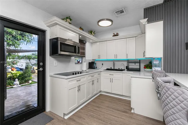 a kitchen with stainless steel appliances granite countertop a stove a sink and a microwave