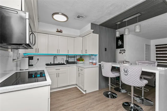 a kitchen with a white cabinets and chairs