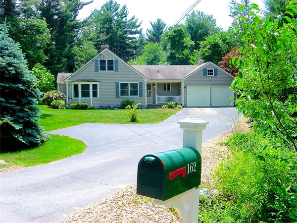 162 Nourse Road Bolton, MA 01740 - Photo 2 of 30 a front view of a house with a yard and garage