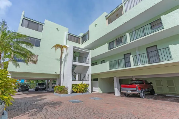 a kitchen with stainless steel appliances granite countertop a dining table chairs a refrigerator and a stove