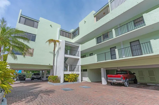 a kitchen with stainless steel appliances granite countertop a dining table chairs a refrigerator and a stove